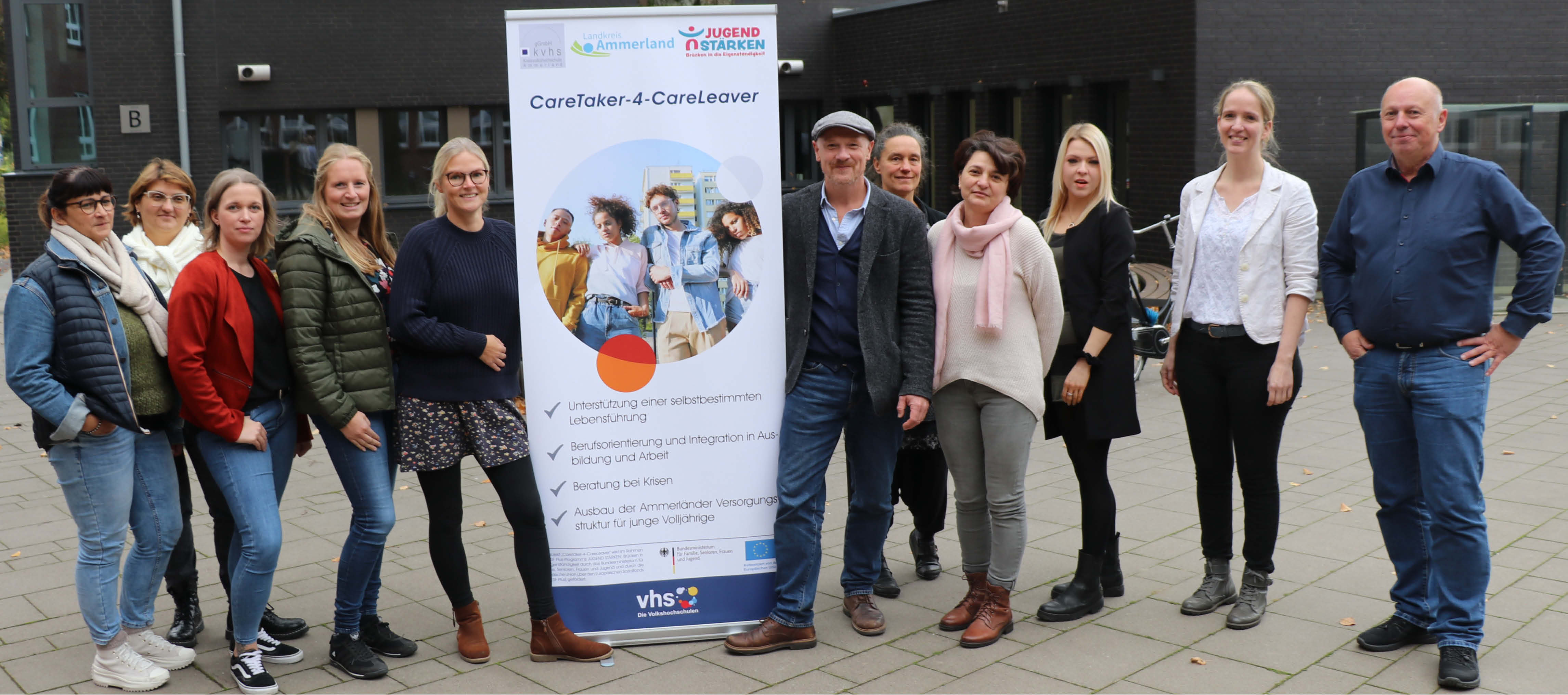 Ein Gruppenfoto der Projektverantortlichen, Mitarbeitenden und Kooperationspartner. In der Mitte steht das Projekt-Roll up