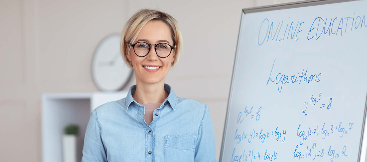 Frau mit Brille steht vor einem Flip-Chart
