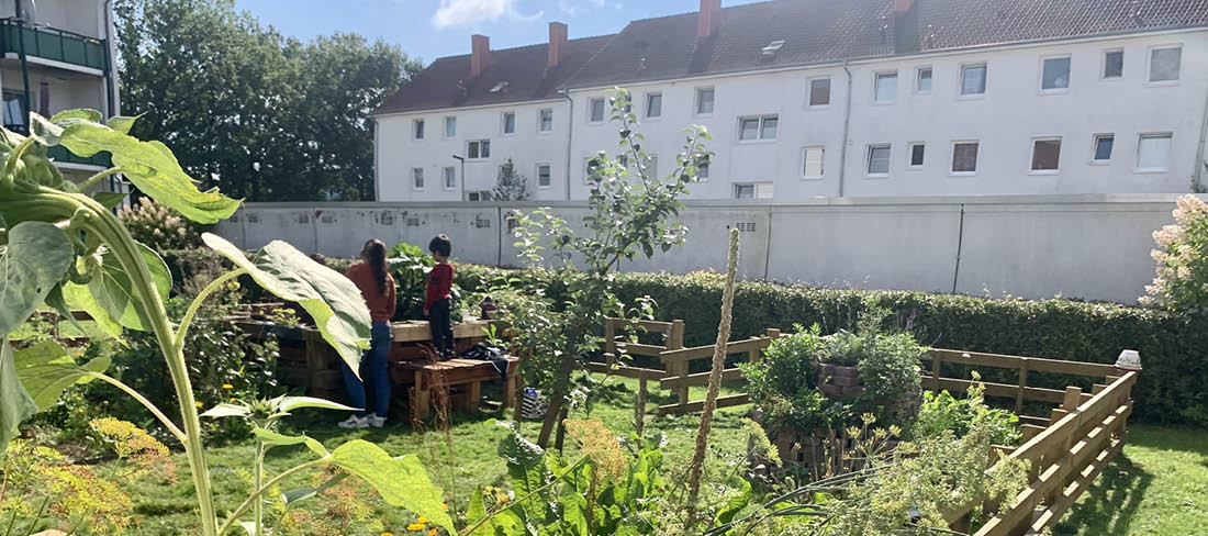 zwei Personen legen die Hände ineinander und halten eine gebastelte Familie