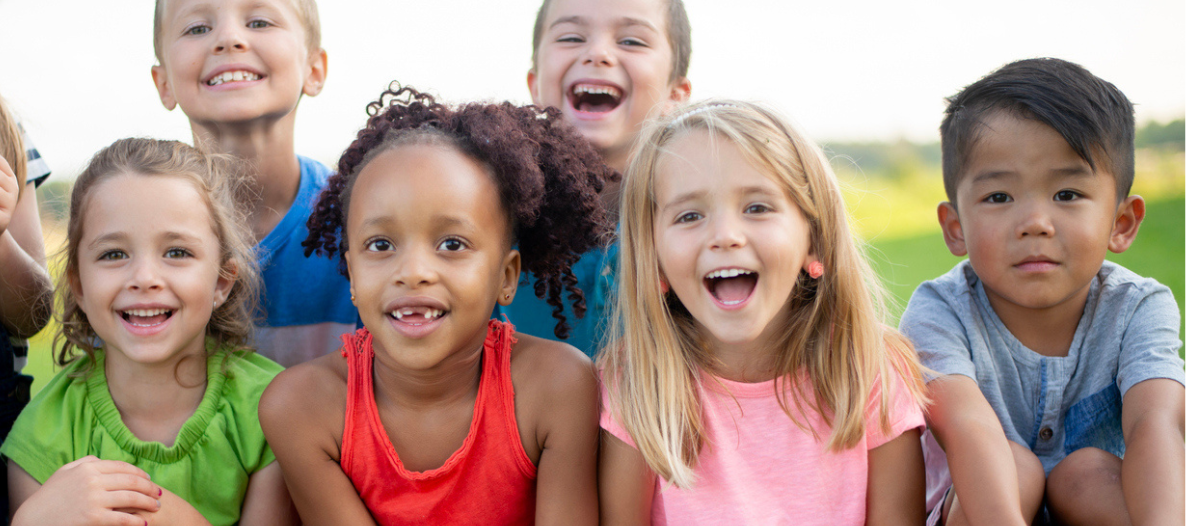 Kinder sitzen im Grass